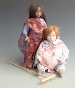 Two dolls one with leather head and body in striped pyjamas 42cm tall the other with bisque head and