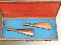 Two shotgun stocks together with a wooden double shotgun carry case 69x34x8cm.