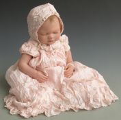 Petra Seiffert wax or vinyl headed reborn doll with closed mouth and eyes and pink dress, 54cm tall.