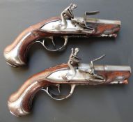 A pair of French flintlock hammer action pocket pistols, the ornately carved stocks decorated with