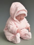 Wax or vinyl headed reborn doll with closed mouth and eyes, soft body and pink outfit, 45cm tall.