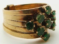 A 14k gold ring made up of five bands set with nine round cut emeralds, 5.5g, size K