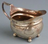Georgian hallmarked silver cream or milk jug with engraved decoration raised on four ball feet,