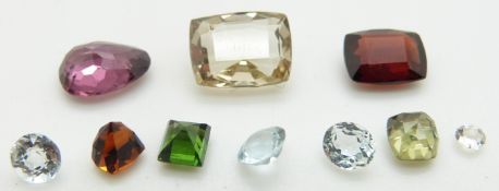 A collection of loose stones including three round cut aquamarines, feldspar, garnet, etc