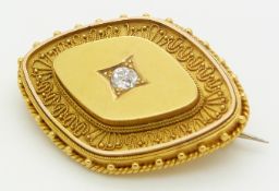 Victorian Etruscan Revival gold brooch set with an old mine cut diamond measuring approximately 0.