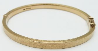 A 9ct gold bangle with raised textured detail, 30.9g
