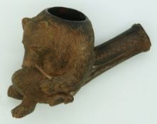 A 19thC/20thC  Black Forest carved pipe in the form of a bear smoking a pipe, approximately 8cm in