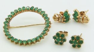 A 9ct gold circular brooch and two pairs of 9ct gold earrings, all set with emeralds