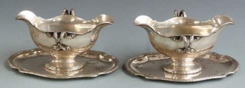 A pair of late 19th or early 20th century German white metal twin handled double ended sauce boats