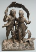 A 19th/20thC spelter figural group of two children using a banana/palm leaf as a sunshade on