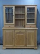 Modern light oak dresser, the top having shelves flanked by glazed display cupboards with drawers