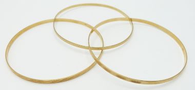 Three 18ct gold bangles with cut out decoration, 13.2g