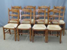 Eight rush seated dining chairs (two carvers and six chairs) with shaped back spars and turned cross