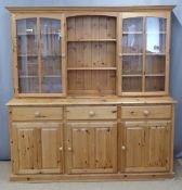 CHARITY Pine dresser, the top having open shelves flanked by glazed display cupboards, the base