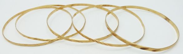 Four 18ct gold bangles with cut out decoration, 13.3g