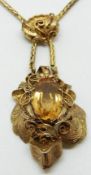 A 15ct gold necklace set with an oval cut citrine within an engraved foliate and filigree border,