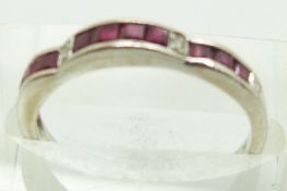 An 18ct white gold ring set with square step cut rubies and four diamonds, 2g, size L