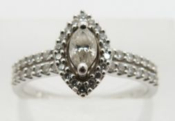A platinum ring set with a marquise cut diamond surrounded by round cut diamonds, total