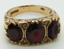 A 9ct gold ring set with three large oval garnets, 4.7g, size P