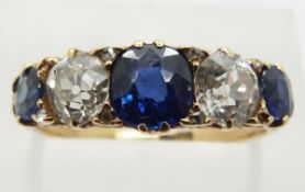 An 18ct gold ring set with three sapphires, the centre stone measuring approximately 1ct, and two