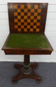 A 19thC rosewood games table the folding swivel top opening to reveal a chess/draughts board and