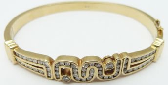 An 18ct gold bangle set with diamonds in an abstract design, 28.7g