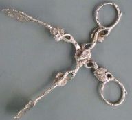 Pair of Victorian hallmarked silver sugar nips with foliate decoration, the hinge surmounted by a