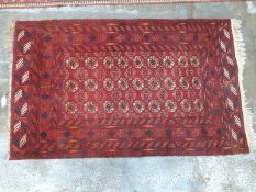Turkoman rug with three lines of gul details on deep red ground within a geometric border, 125 x
