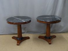 A pair of walnut and mahogany console tables set with circular black-marble tops and ebonised