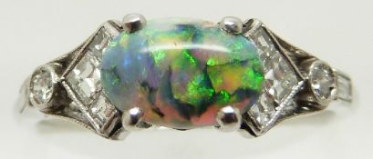 Art Deco platinum ring set with an oval opal cabochon and square, baguette and round cut diamonds,