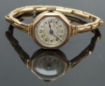 9ct gold ladies wristwatch with Arabic numerals and gold highlighted silver dial, on 9ct gold