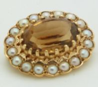 A 9ct gold brooch set with an oval cut citrine surrounded by seed pearls, 2.2 x 1.8cm