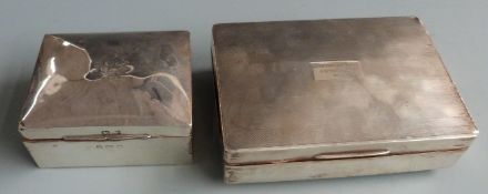 Two hallmarked silver cigarette boxes, width of larger 16.5cm