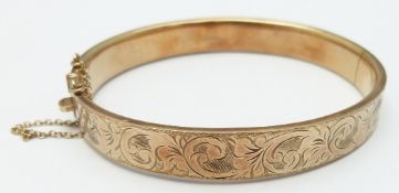 A 9ct gold bangle with engraved decoration, 12.7g
