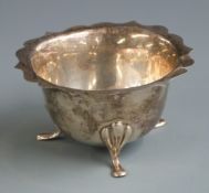 George V hallmarked silver sugar bowl with shaped edge and raised on three feet, marks rubbed but
