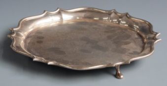 Edward VII hallmarked silver salver with shaped edge and raised on three feet, London 1909 maker