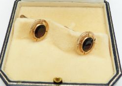 A pair of 9ct gold cufflinks set with an oval cut garnet to each, 7.5g