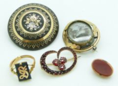 An inlaid Victorian brooch, a mourning brooch, and a Victorian brooch set with Bohemian rose cut