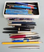 A collection of pens and writing instruments including Parker Duofold.