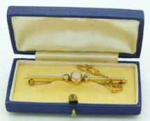 A yellow metal brooch set with an opal cabochon and diamonds with a platinum finish, in vintage box