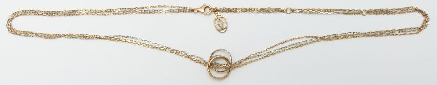 A Cartier tri-coloured gold necklace with a tri-coloured gold ring pendant in original Cartier