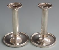 Pair of George V hallmarked silver candlesticks with castellated bases and tops, Birmingham 1928