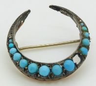 Victorian crescent brooch set with graduated turquoise cabochons and two diamonds, 3.1cm