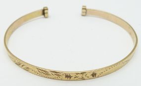 A 9ct gold bangle with engraved decoration, 5.4g