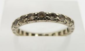A white metal eternity ring set with paste, size M, 1.9g.