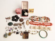 An agate necklace, silver locket, filigree silver brooch, coral necklace, bone bracelet, silver