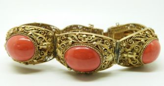 A silver gilt filigree bracelet set with coral cabochons