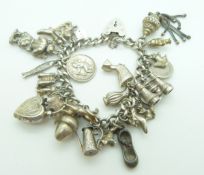 A silver charm bracelet with a large quantity of charms including ladybird, St Christopher, dog,