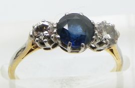An 18ct gold ring set with a round cut sapphire measuring approximately 1.14ct and two round cut