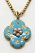 An early Victorian pendant set with aqua coloured enamel, a central ruby and seed pearls, with glass